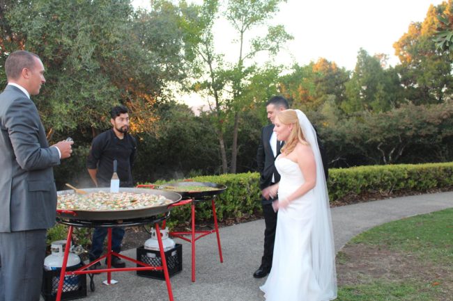 Bride and groom admire paella